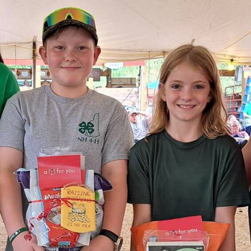 A young boy and girl holding up gift baskets