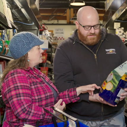 employee assisting customer with poultry feed